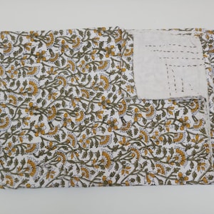 May include: White cotton fabric with a floral pattern in shades of yellow and green. The fabric is folded in half and has a white border around the edges.