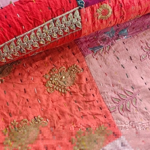 Pode incluir: Uma colcha de retalhos com uma variedade de cores e texturas. A colcha &eacute; feita de diferentes tecidos, incluindo rosa, vermelho e laranja. A colcha &eacute; decorada com bordados e lantejoulas.