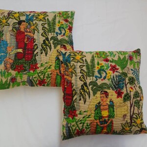May include: Two square throw pillows with a beige background and a colorful floral pattern. The pattern includes green leaves, red flowers, and images of women with dark hair and colorful clothing.