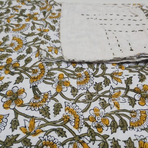 May include: White cotton kantha quilt with a floral pattern in shades of yellow and green. The quilt is hand-stitched and has a rustic, vintage look.