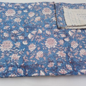 May include: A blue and white kantha quilt with a floral pattern. The quilt is made of cotton and is hand-stitched. It is a traditional Indian textile.
