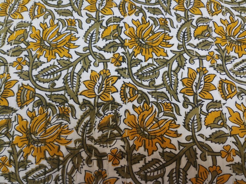 May include: White fabric with a repeating pattern of yellow and green floral designs. The fabric has a subtle texture.