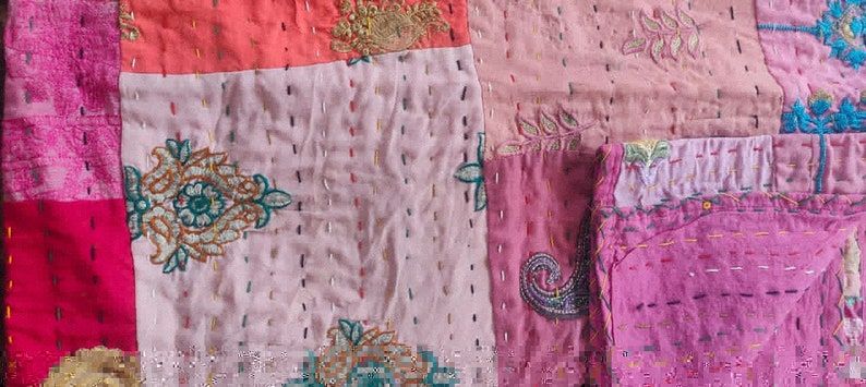 Pode incluir: Um cobertor de retalhos com uma variedade de cores e padr&otilde;es, incluindo rosa, vermelho e verde. O cobertor &eacute; feito de diferentes tecidos e tem um visual vintage.