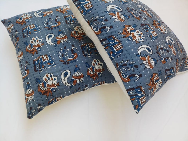 May include: Two blue and white patterned pillow covers with a white border. The pattern features peacocks, elephants, and paisley designs.