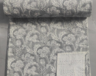May include: A grey and white kantha quilt with a floral pattern. The quilt is folded in half and the white side is visible.