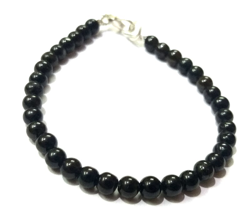 May include: A black beaded bracelet with a silver clasp.