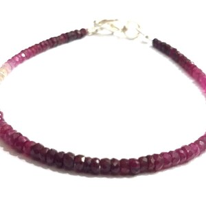 May include: A delicate bracelet made with a gradient of pink and white gemstone beads. The bracelet is strung on a silver chain with a lobster clasp.