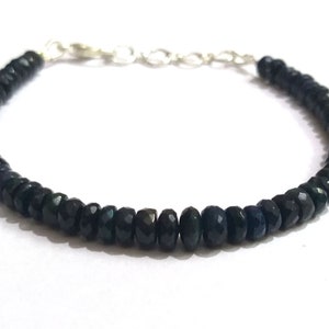 Op de afbeelding: Een armband van zwarte edelstenen met een zilveren sluiting. De armband is gemaakt van kleine, gefacetteerde kralen.