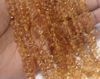 Könnte beinhalten: Eine Strähne aus goldenen Citrin-Edelsteinkugeln, facettiert und rund, mit leicht unregelmäßiger Form. Die Perlen sind auf einem Draht aufgereiht und haben einen Durchmesser von etwa 4 mm.