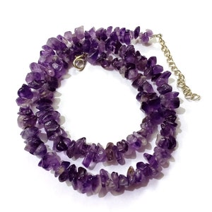 May include: A purple amethyst chip necklace with a silver clasp. The necklace is made of small, irregular shaped amethyst chips.