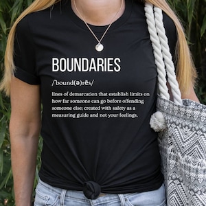 May include: Black t-shirt with white text that reads "BOUNDARIES /'bound(ə)rēs/ lines of demarcation that establish limits on how far someone can go before offending someone else; created with safety as a measuring guide and not your feelings."