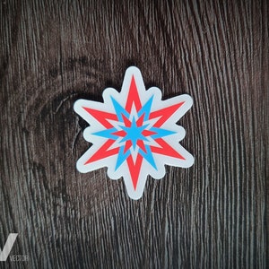 May include: A white sticker with a red and blue starburst design. The starburst has a white border and is centered on a dark brown wooden surface. The text "VISIBLY VECTOR" is in the bottom left corner.