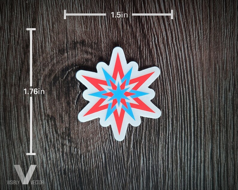 May include: A sticker with a starburst design in red and blue, outlined in white. The sticker measures 1.76 inches tall and 1.5 inches wide. The sticker is on a dark wood grain surface.