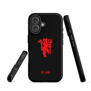 May include: Black phone case with a red devil logo and the text "EST. 1878". The case is shown with two other black phone cases, one on the side and one leaning against the main case.