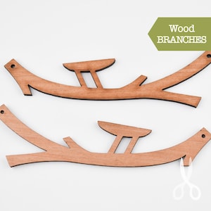 May include: Two wooden branches with a cutout design. The branches are light brown and have a natural wood finish. The text "Wood Branches" is printed on a green rectangle in the upper right corner of the image.