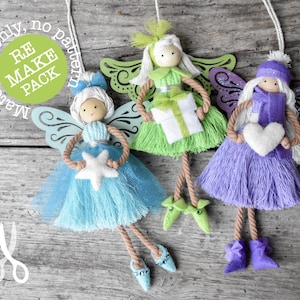 May include: Three handmade fairy ornaments with wooden doll heads, yarn skirts, and decorative wings. One fairy is blue with a star, another green with a gift, and the last purple with a heart. The ornaments are suspended by white string.