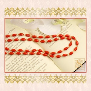 May include: A red and white coral bead necklace on an open book with the text "When your friend speaks, fear not the "nay" in your heart, do you withhold the "ay."