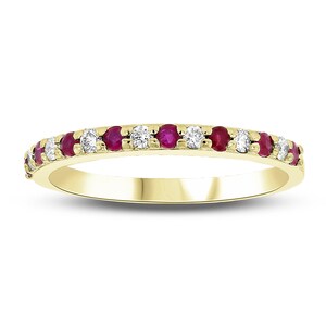 May include: A gold band ring set with alternating round rubies and diamonds. The ring features a classic design with the gemstones set closely together, creating a continuous sparkle. The ring is a delicate piece of jewelry.
