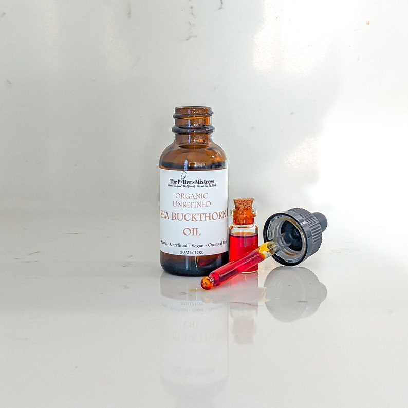 May include: A brown glass bottle with a dropper filled with orange liquid. The bottle is labeled "The Potter's Mistress Organic Unrefined Sea Buckthorn Oil 30mL/1.02 oz."