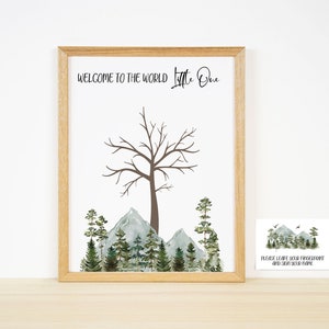 Pu&ograve; includere: Una stampa incorniciata con un'illustrazione ad acquerello di un albero con montagne e pini sullo sfondo. Il testo "Welcome to the world Little One" &egrave; in cima alla stampa. Un biglietto pi&ugrave; piccolo con il testo "Please leave your fingerprint and sign your name" &egrave; nell'angolo in basso a destra dell'immagine.