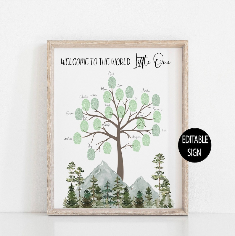Puede incluir: Un cartel imprimible de bienvenida al mundo con un &aacute;rbol verde cuyas hojas son espacios para huellas dactilares. El &aacute;rbol est&aacute; rodeado de monta&ntilde;as y pinos. El texto "Bienvenido al mundo Peque&ntilde;o" est&aacute; en la parte superior del cartel. El cartel est&aacute; enmarcado en un marco de madera claro.