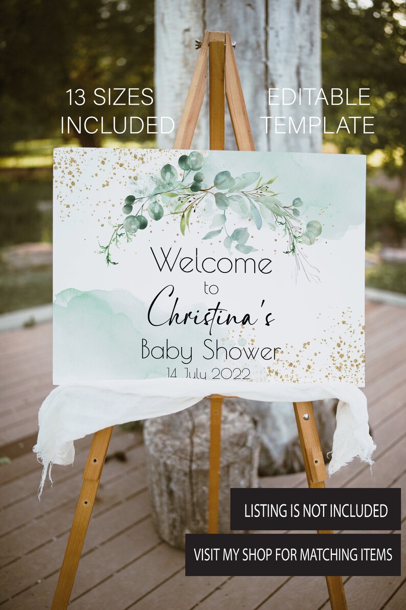 May include: A welcome sign for a baby shower with a watercolor background in shades of blue and green. The sign features a leafy garland with gold glitter accents and the text "Welcome to Christina's Baby Shower 14 July 2022".