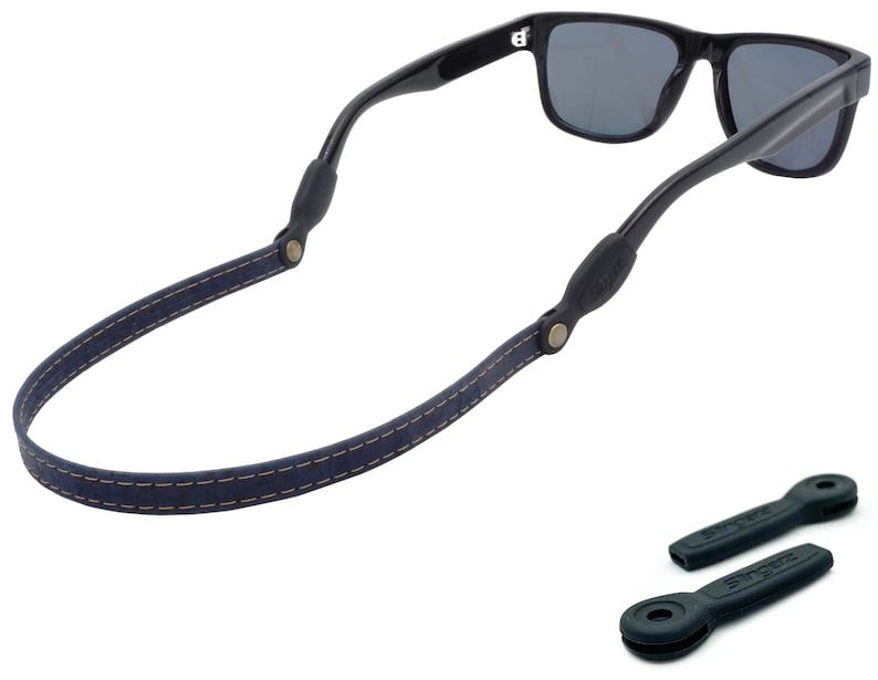 K&ouml;nnte beinhalten: Ein dunkelblaues Lederband f&uuml;r Sonnenbrillen mit einem gen&auml;hten Design und schwarzen Gummieins&auml;tzen. Das Band ist an einer schwarzen Sonnenbrille befestigt.