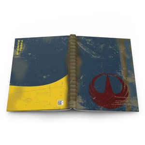 May include: An open book with a blue and yellow cover and a red symbol on the right page. The book has a worn and distressed look, giving it a vintage feel.