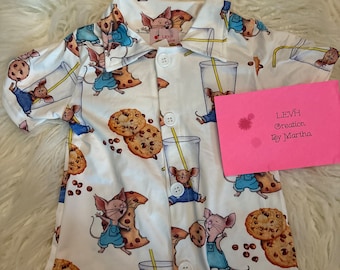 May include: White button-up shirt with a pattern of mice holding cookies and drinking milk. The shirt has a collar and short sleeves. The text "LEVH Creation By Martha" is on a pink card in the background.