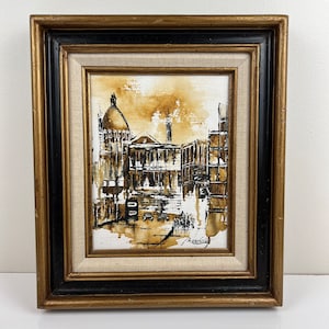 May include: A framed black and white painting of a city scene with a domed building in the background. The painting is done in a loose, impressionistic style and has a warm, sepia tone.