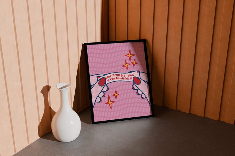 Peut inclure: Une affiche rose encadr&eacute;e avec le texte "WHAT'S THE BEST THAT COULD HAPPEN ?" tenue par des mains de dessin anim&eacute; avec des ongles rouges. L'affiche a un motif ondul&eacute; et des &eacute;toiles dor&eacute;es. Un vase blanc est devant.
