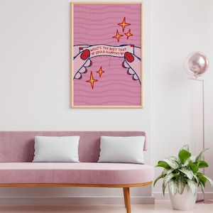 Peut inclure: Une affiche encadr&eacute;e avec un fond rose et le texte "WHAT'S THE BEST THAT COULD HAPPEN ?" L'&oelig;uvre repr&eacute;sente des mains tenant une banni&egrave;re avec le texte, entour&eacute;e d'&eacute;toiles. L'affiche est affich&eacute;e au-dessus d'un canap&eacute; rose.