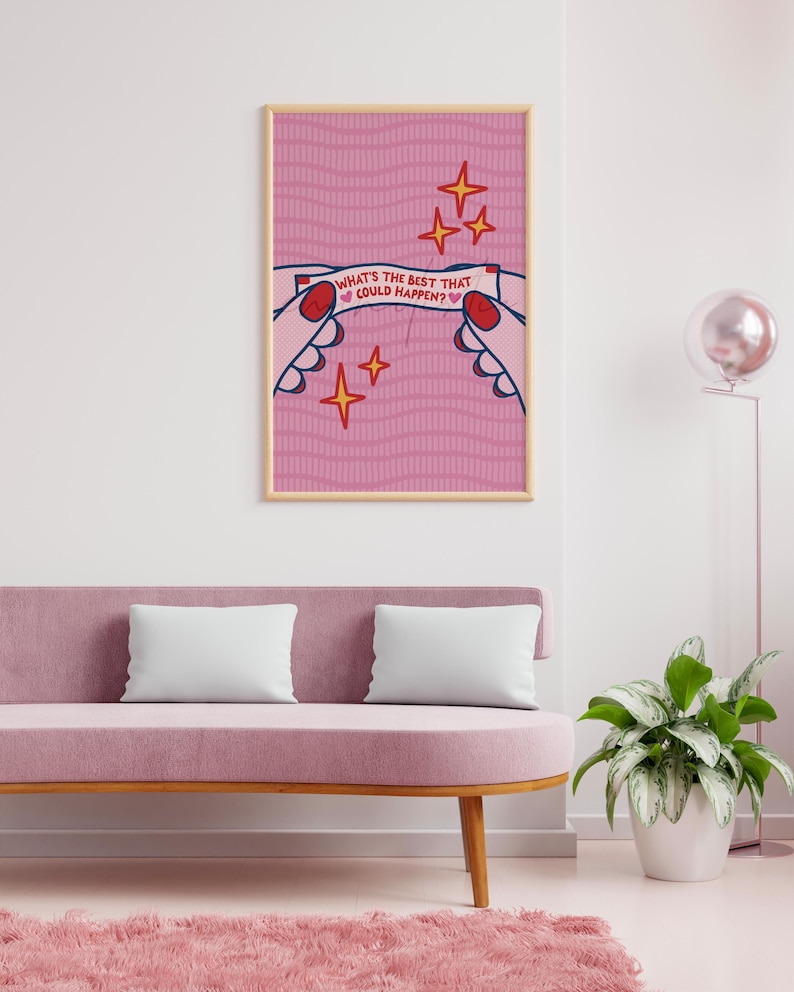 Peut inclure: Une affiche encadr&eacute;e avec un fond rose et le texte "WHAT'S THE BEST THAT COULD HAPPEN ?" L'&oelig;uvre repr&eacute;sente des mains tenant une banni&egrave;re avec le texte, entour&eacute;e d'&eacute;toiles. L'affiche est affich&eacute;e au-dessus d'un canap&eacute; rose.