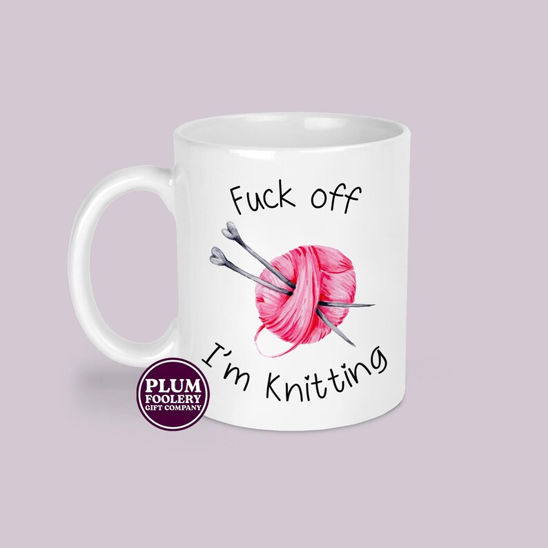 11oz ceramic mug in all white, mug only. It has the words “Fuck off I’m knitting” with an illustration of a pink ball of yarn with knitting needles. mug is microwave & dishwasher safe.
