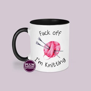11oz ceramic mug in white with black accents, mug only. It has the words “Fuck off I’m knitting” with an illustration of a pink ball of yarn with knitting needles. mug is microwave & dishwasher safe.