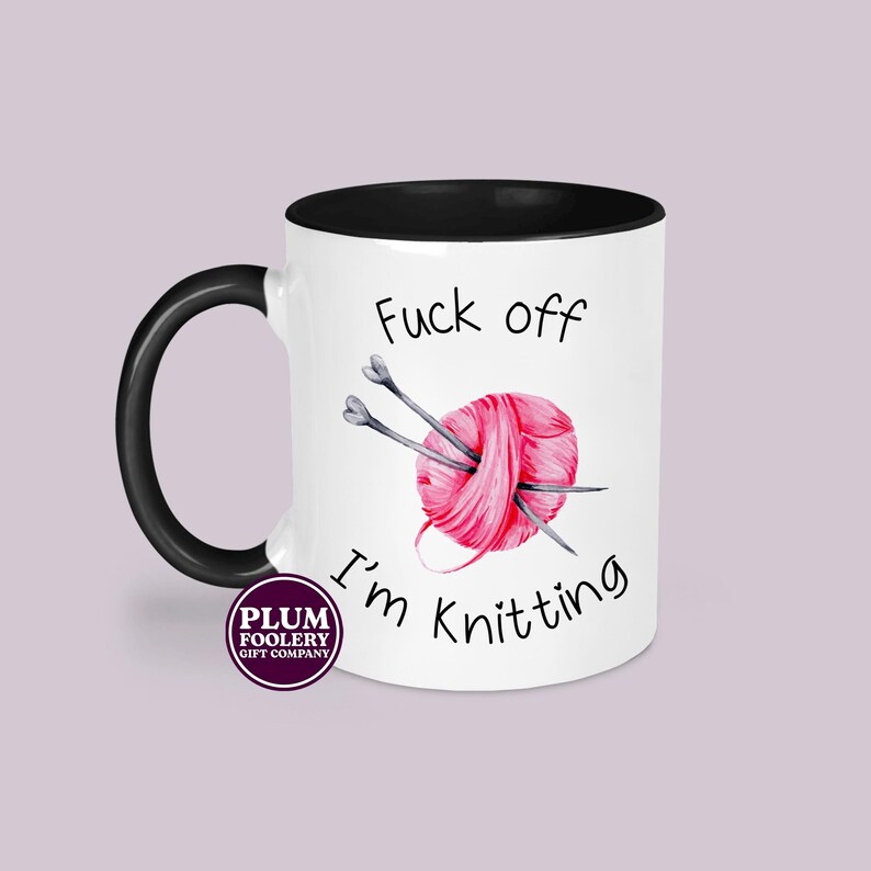 11oz ceramic mug in white with black accents, mug only. It has the words “Fuck off I’m knitting” with an illustration of a pink ball of yarn with knitting needles. mug is microwave & dishwasher safe.