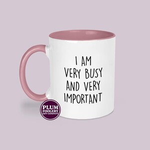 Pink handled funny office mug with humorous busy and important quote