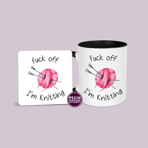 11oz ceramic mug in white with black accents and an optional white MDF matching coaster. It has the words “Fuck off I’m knitting” with an illustration of a pink ball of yarn with knitting needles. mug is microwave & dishwasher safe.