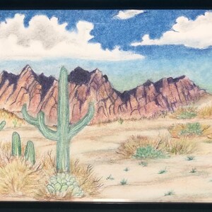 May include: A colorful pencil drawing of a desert landscape with mountains in the background, a blue sky with white clouds, and several green cacti in the foreground.