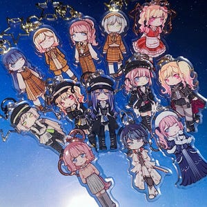 May include: A selection of anime-style character keyrings. Each keyring showcases a unique character design with detailed outfits and hairstyles. The keyrings are made of clear acrylic and attached to metal key rings.