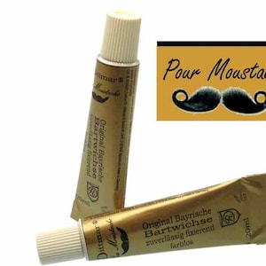 Puede incluir: Dos tubos de cera para bigote Original Bayrische Bartwichse, uno con la etiqueta hacia adelante y el otro con la etiqueta hacia atrás. La etiqueta es dorada con texto negro y una pequeña imagen de un bigote. El texto de la etiqueta dice "Original Bayrische Bartwichse zuverlässig fixierend farblos" y "20ml".