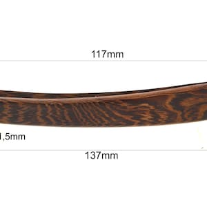 Può includere: Un rasoio dritto in legno marrone con un perno dorato all'estremità. Il rasoio è lungo 137 mm, spesso 1,5 mm, largo 117 mm e alto 20 mm.
