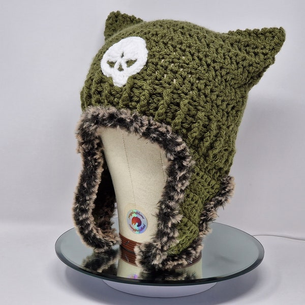 Handgemachte gehäkelte Katzenmütze, Katzenohren Mütze, Katzenohren Mütze in Khaki Grün mit einem Totenkopf Motiv und flauschigen Ohrenklappen