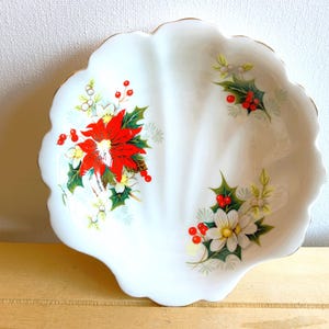Royal Albert shell-shaped small dish in the Christmas Yuletide pattern. White glaze with a pattern of poinsettias.