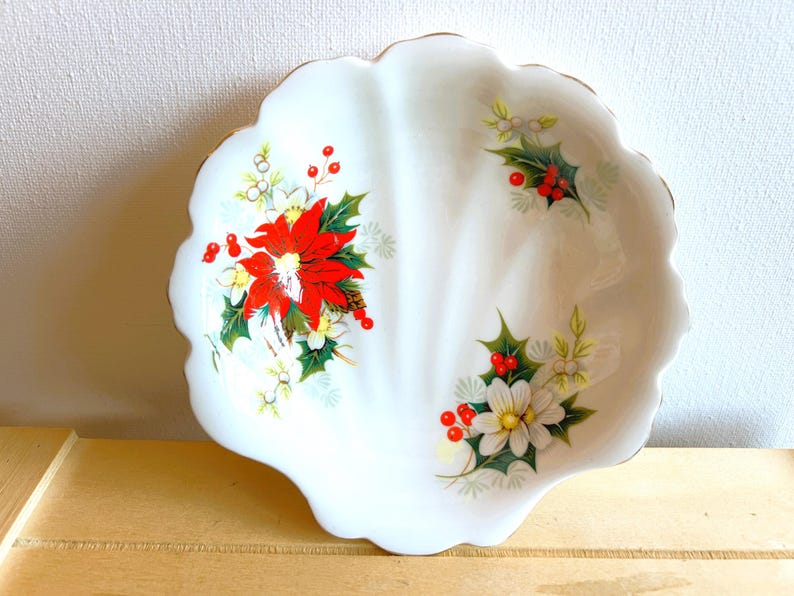 Royal Albert shell-shaped small dish in the Christmas Yuletide pattern. White glaze with a pattern of poinsettias.