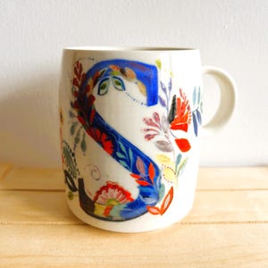 Vintage Petal Palette mug designed by American fine artist, Starla M Halfmann for Anthropologie. The letter "S" entwined in beautiful flowers.
