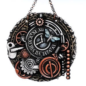 May include: A circular, black, metal wall clock with Roman numerals and a butterfly design. The clock has a steampunk aesthetic with gears and other intricate details.