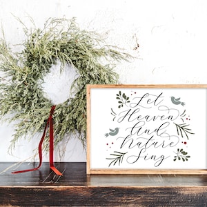 May include: A framed wood sign with a white background and a green and black floral design. The sign says "Let Heaven and Nature Sing".