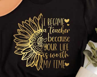 May include: Black t-shirt with a gold sunflower graphic and the text "I became a teacher because your life is worth my time".