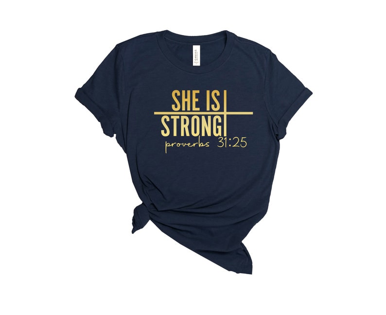 May include: Navy blue t-shirt with gold lettering that reads "She is Strong" and "Proverbs 31:25".